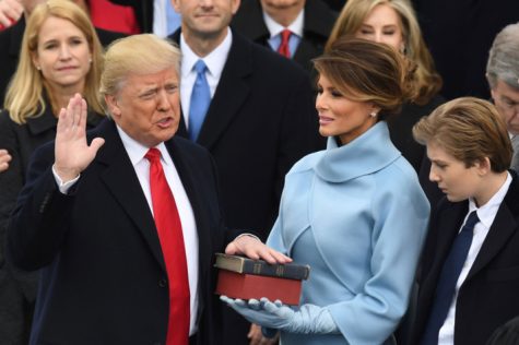 Donald Trump is sworn in as wife Melania Trump holds the bible.