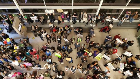 Protesters against President Trump's executive order stand in the Indianapolis International Airport on Sunday, January 29. About 500 people attended, including well-known teen author John Green.